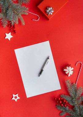 Yaratıcı tasarım kırmızı zemin ve Noel ağaçlarının dalları, hediyeler, baston şekerler ve kağıt kart notları. 