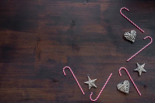 五彩缤纷的圣诞装饰品 形似一颗星 心形像一颗红心 背景是深色木制的糖果手杖 背景是圣诞 — 图库照片