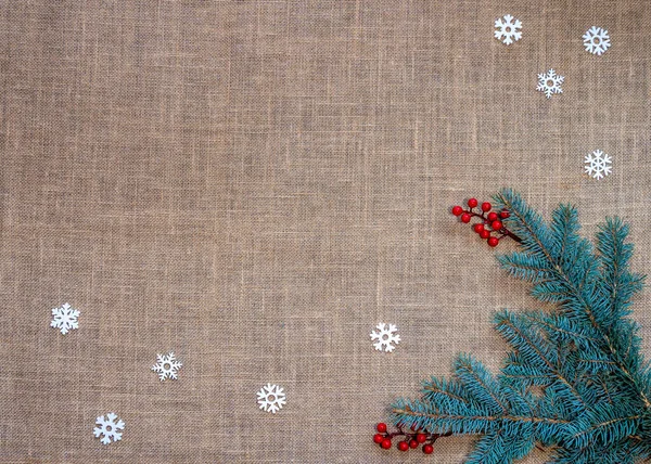 トウヒの枝 雪の結晶とベリーの枝 コピースペース クリスマスの背景のフレームとバラップの背景 — ストック写真