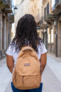 Büyük sırt çantalı turist kız Salamanca 'daki tarihi Ciudad Rodrigo kasabasının sokaklarında yürüyor..