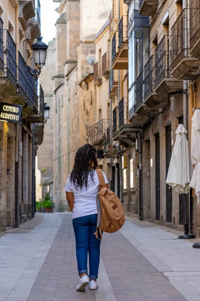 stock image Tourist girl with large backpack taking a walk through the streets of the historic town of Ciudad Rodrigo in Salamanca.