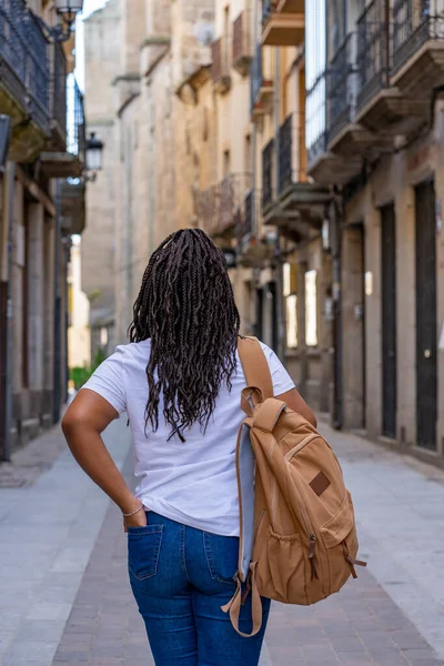 Büyük sırt çantalı turist kadın Salamanca 'daki tarihi Ciudad Rodrigo kasabasının sokaklarında yürüyor..