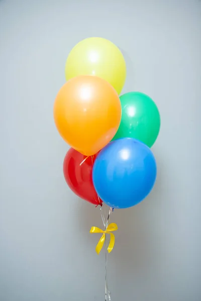 a bouquet of colorful balloons for the holiday on the background of the wall