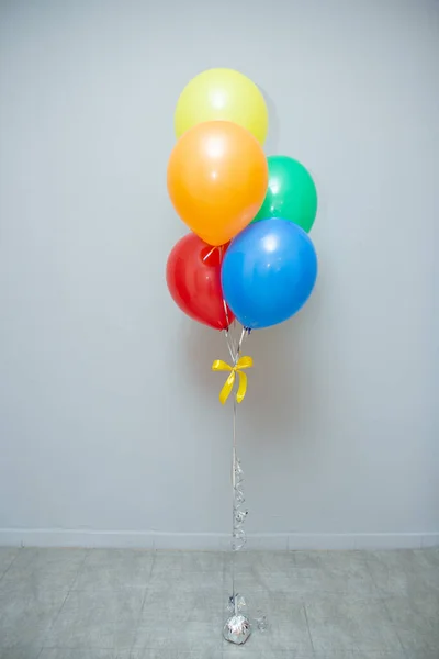 a bouquet of colorful balloons for the holiday on the background of the wall