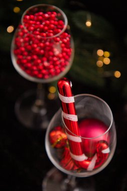 Bardakta yeni yıl oyuncakları, Noel ağacının yanında kırmızı yeni yıl süslemeleri.