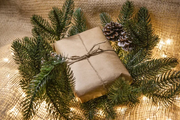 木の横のクラフト紙のクリスマスプレゼント — ストック写真