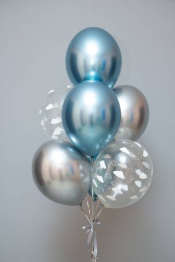 Gri arkaplanda mavi ve gümüş balonlar