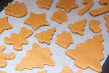 Kurabiye tepsisindeki beyaz parşömen üzerinde zencefilli ekmek.