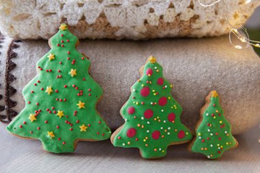 Ekoseli arkaplanda Noel ağacı şeklinde üç zencefilli kurabiye.