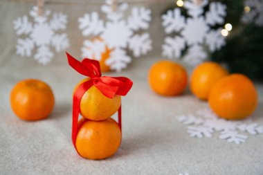 Kırmızı kurdeleli mandalinalar ve masada Noel ağacı kurabiyeleri.