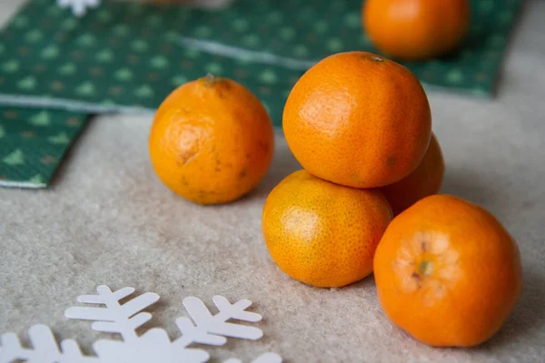 stock image tangerines and paper snowflakes on a wooden background