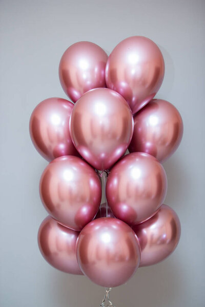 набор розовых хромированных шариков на фоне стен