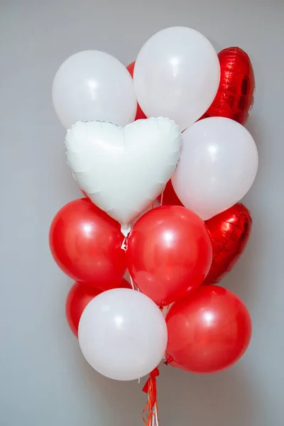 red and white balloons on the background of the wall, a set of red balloons. Inscriptions on foil hearts: \