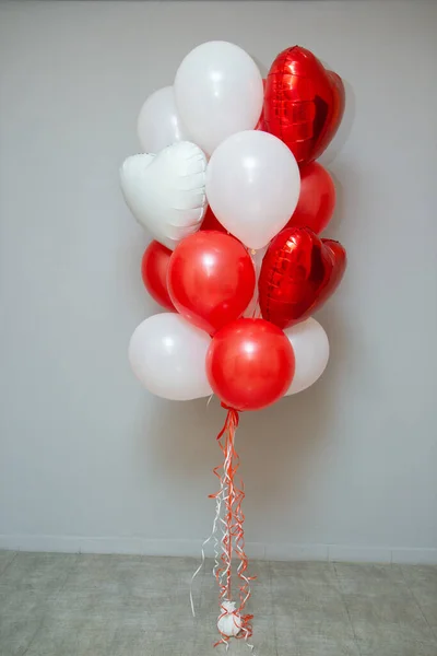 red and white balloons on the background of the wall, a set of red balloons. Inscriptions on foil hearts: 