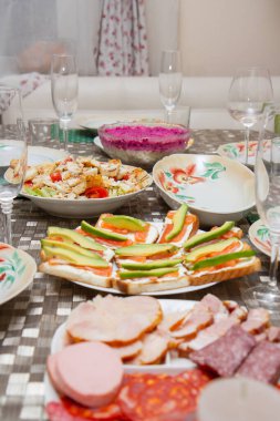 Tabakta peynir dilimleri ve pancar kürkünün altında ringa salatası.