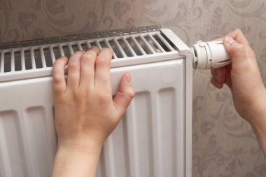 hand holding switch on radiator