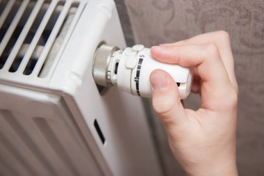 hand holding switch on radiator