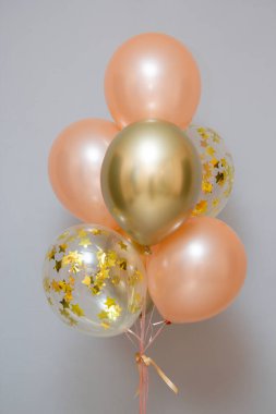Set of pink and gold balloons on the background of the wall, card with balloons