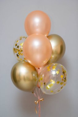 Set of pink and gold balloons on the background of the wall, card with balloons