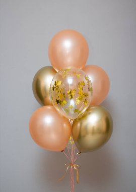 number one pink balloon and a bunch of latex balloons with helium for a birthday, a composition of balloons for 1 year old for a girl