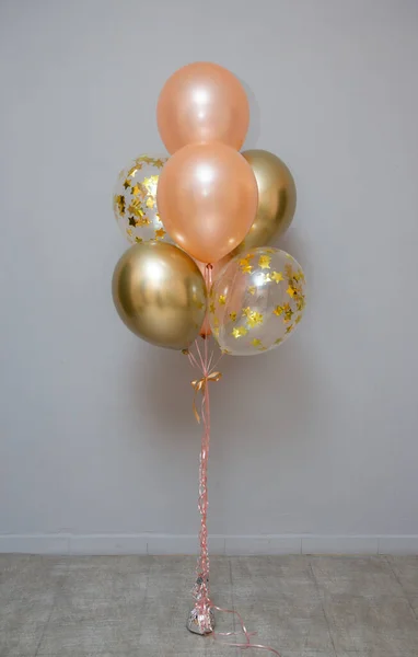 Set of pink and gold balloons on the background of the wall, card with balloons