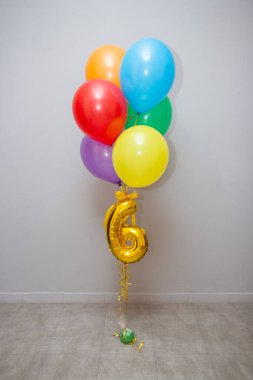 Siyah arka planda çok renkli balonlar, 6 numaralı altın folyo balonu.