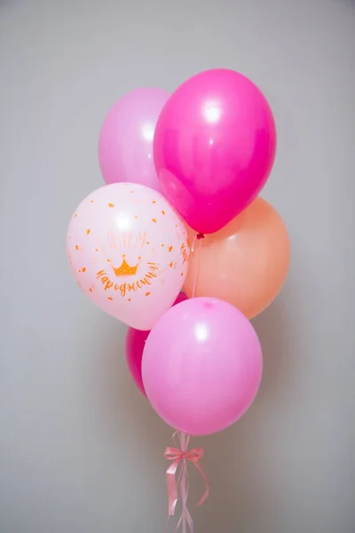 pink balloons with helium on a gray background, the inscription \