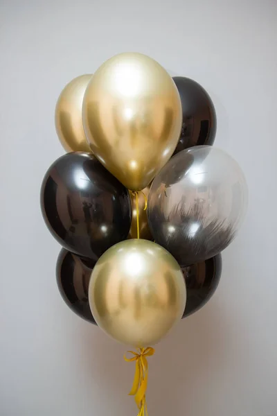 golden chrome and black balloons, bunch of balloons on wall background