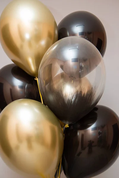 golden chrome and black balloons, bunch of balloons on wall background