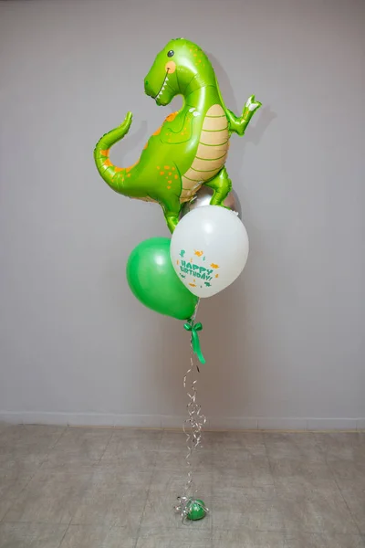 green dinosaur, foil balloon green dinosaur with latex balloons on the background of the wall, postcard with a dinosaur