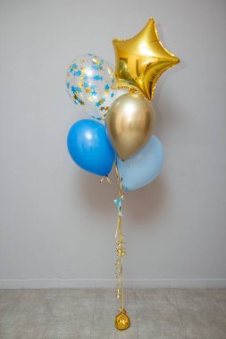 Bir çocuğun doğum günü için mavi ve altın renkli balonlar.