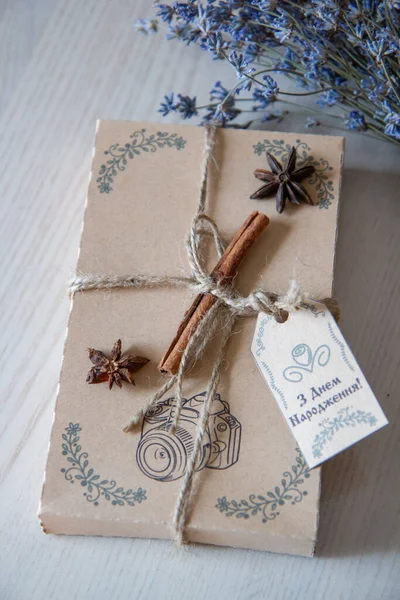 brown birthday gift box with a cinnamon stick and a bouquet of lavender, the inscription \