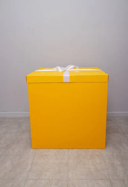 Una Gran Caja Cartón Amarillo Con Lazo Fondo Pared Una — Foto de Stock