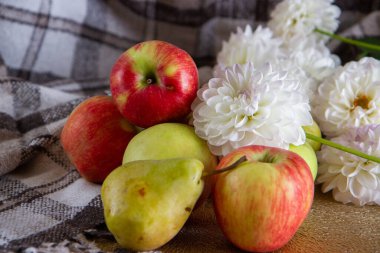Masadaki parlak taze elmalar ve çiçekler
