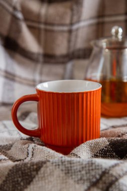 turuncu kupa ve çaydanlık bej bir battaniyede çay