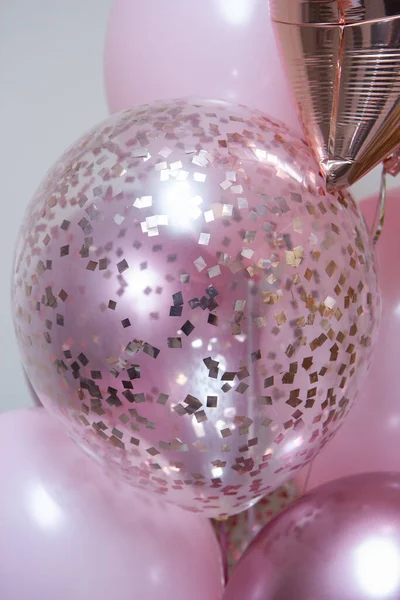 Beyaz zemin üzerinde helyum bulunan bir grup pembe balon.