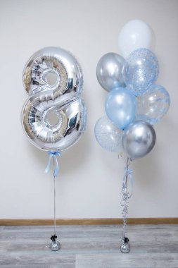 Gümüş numara 8 ve beyaz arkaplanda mavi helyum balonları.
