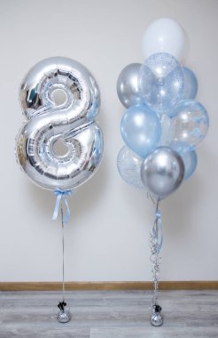 Gümüş numara 8 ve beyaz arkaplanda mavi helyum balonları.