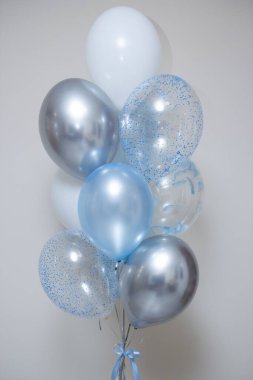 Beyaz arka planda gümüş ve mavi balonlar, mutlu yıllar.