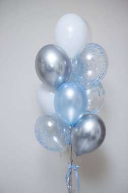 Beyaz arka planda gümüş ve mavi balonlar, mutlu yıllar.