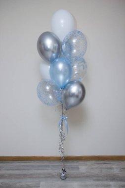 Beyaz arka planda gümüş ve mavi balonlar, mutlu yıllar.