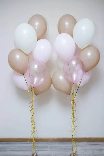 pink and beige balloons for the holiday on a white background, photo zone made of pink helium balloons