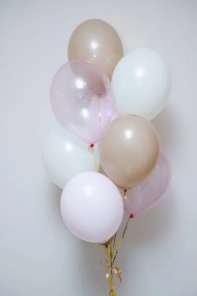 pink and beige balloons for the holiday on a white background, photo zone made of pink helium balloons