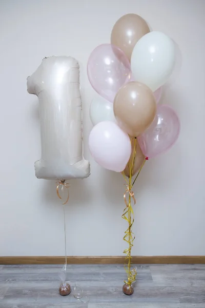 beige number one helium balloon and set of pink balloons on white background