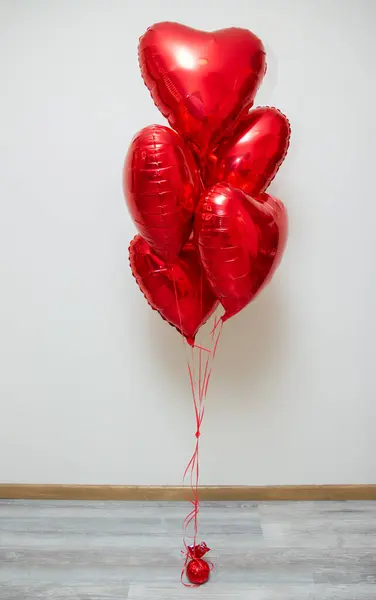 red heart balloons with helium on a white background in a bunch