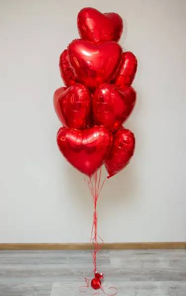 red heart balloons with helium on a white background in a bunch