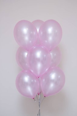 Beyaz arkaplanda inci kokulu pembe balonlar