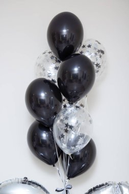 Beyaz arka plandaki bir adam için bir sürü siyah ve gümüş balon.