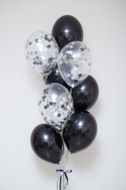 Beyaz arka plandaki bir adam için bir sürü siyah ve gümüş balon.