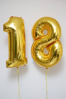 Beyaz arkaplanda 18 numaralı altın balonlar
